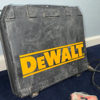 Sale Photo Thumbnail #603: Black plastic DeWalt hard power tool case with yellow branding, showing light surface scuffs and wear.