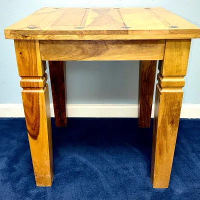 Sale Photo Thumbnail #734: Rustic solid wood end table featuring a plank top with small dark inlay details and square tapered legs with carved notch accents.