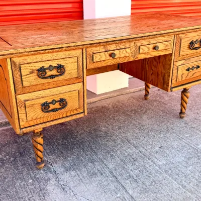 Sale Photo Thumbnail #256: Vintage oak executive desk featuring twisted rope legs, dark metal bail hardware, and side inlay details.