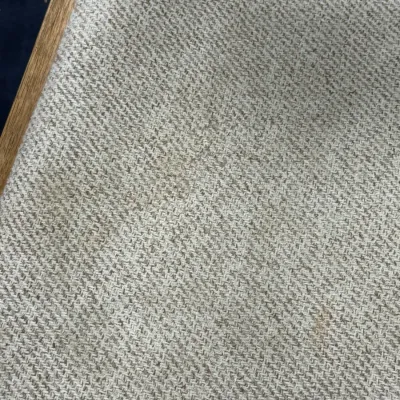 Sale Photo Thumbnail #701: Close-up view of textured beige herringbone upholstery fabric framed in light wood.