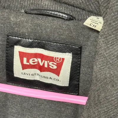 Sale Photo Thumbnail #878: Close-up of the interior tag of a grey Levi Strauss & Co. jacket, size small.