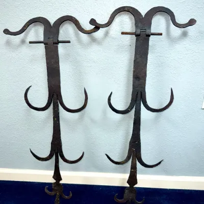 Sale Photo Thumbnail #644: Pair of antique hand-forged wrought iron wall-mounted rack fixtures or hooks featuring scroll and fleur-de-lis motifs.