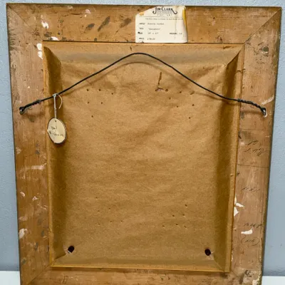 Sale Photo Thumbnail #143: Back side of a framed oil painting by Beverly Hoebel, titled 'Manuelito', featuring a gallery tag from Jim Clark Fine Art and attached hanging wire.