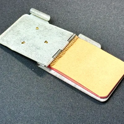 Sale Photo Thumbnail #200: Vintage metal pocket notepad case with hinged cover and small paper pad.