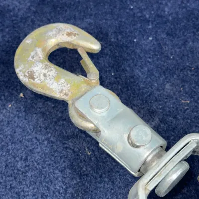 Sale Photo Thumbnail #656: Heavy-duty steel winch cable hook with safety latch and swivel attachment, showing light wear and surface oxidation.