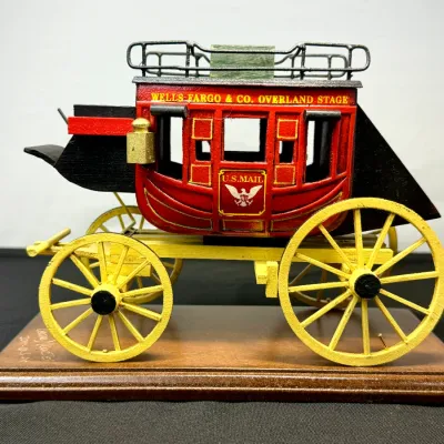 Sale Photo Thumbnail #39: Handcrafted wooden Wells Fargo & Co. Overland Stage stagecoach scale model mounted on a wooden display base.