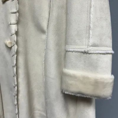 Sale Photo Thumbnail #849: Off-white faux shearling suede coat with toggle buttons and faux fur cuffs.