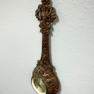 Sale Photo Thumbnail #392: Vintage ornate carved wood wall clock with baroque-style scrolling and a round brass dial.
