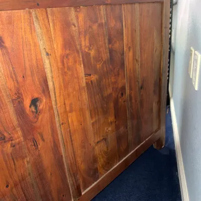 Sale Photo Thumbnail #254: Solid wood bar or counter constructed from rich, warm-toned planks with prominent natural grain and knot detailing.