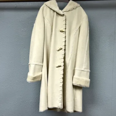 Sale Photo Thumbnail #91: Off-white faux shearling hooded coat featuring toggle closures, whipstitch trim details, and cuffed sleeves.