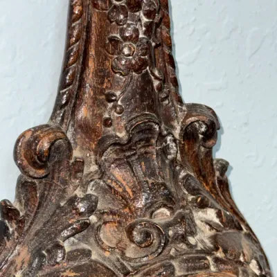 Sale Photo Thumbnail #395: Detail view of an antique carved dark wood wall clock featuring intricate floral and acanthus leaf relief motifs.