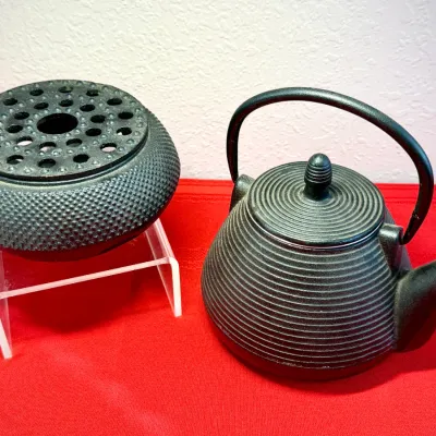 Sale Photo Thumbnail #463: Japanese black cast iron tetsubin teapot with ribbed body and matching textured trivet teapot warmer.