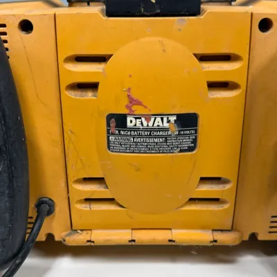 Sale Photo Thumbnail #911: DeWalt jobsite radio with integrated 1-hour NiCd battery charger (7.2V–18V), showing heavy wear and cosmetic scuffs.