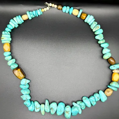 Sale Photo Thumbnail #24: Southwestern-style beaded necklace featuring chunk and disc-shaped turquoise nuggets interspersed with tiger's eye and other polished stone accent beads, finished with a metal lobster claw clasp.
