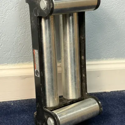 Sale Photo Thumbnail #669: Heavy-duty winch roller fairlead with a black metal frame and silver steel rollers, showing light signs of wear.