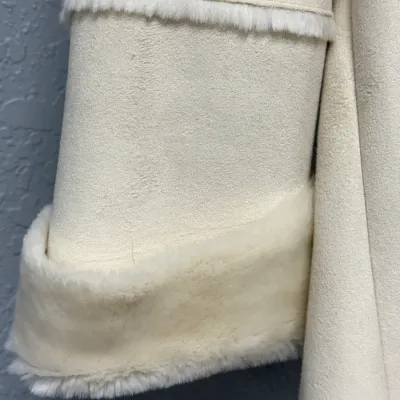 Sale Photo Thumbnail #846: Close-up detail of an off-white faux suede winter coat featuring plush faux fur trim on the sleeve cuff and seams.