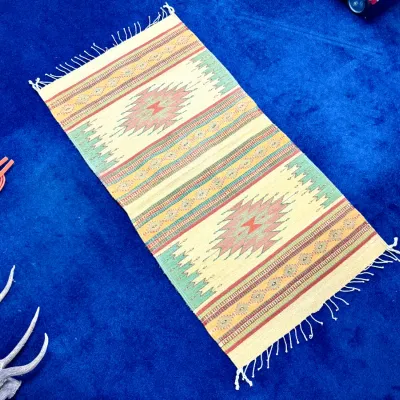 Sale Photo Thumbnail #418: Handwoven Southwestern or Mexican flat-weave runner rug featuring geometric diamond patterns and fringe in pastel green, coral, and cream tones.