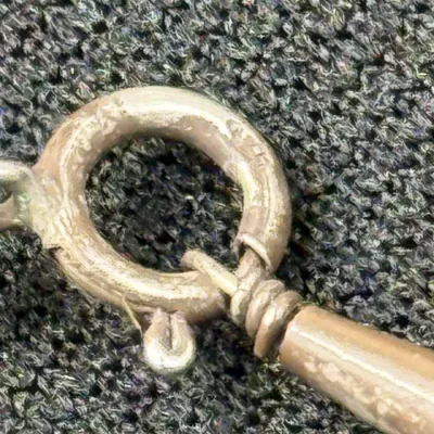 Sale Photo Thumbnail #176: Close-up view of a silver spring ring clasp attached to a wrapped wire loop and chain element.