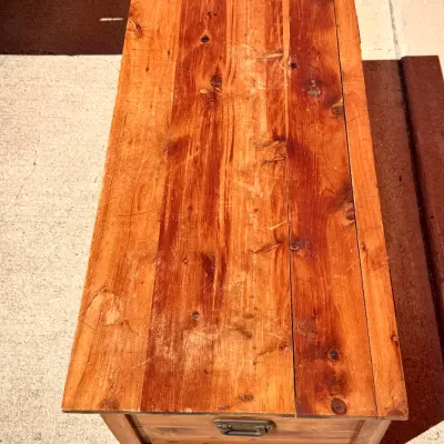Sale Photo Thumbnail #319: Rustic wooden storage chest with a warm finish, featuring metal side handles and natural wood grain with light surface wear.