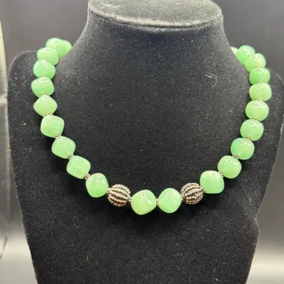 Sale Photo Thumbnail #337: Light green aventurine or jadeite bead necklace featuring silver-tone accent beads on a black jewelry bust.
