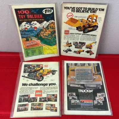 Sale Photo Thumbnail #802: Group of four vintage comic books featuring classic back-cover advertisements for Lego Expert Builder series, Monogram Models, and plastic toy soldiers, all housed in protective plastic sleeves.