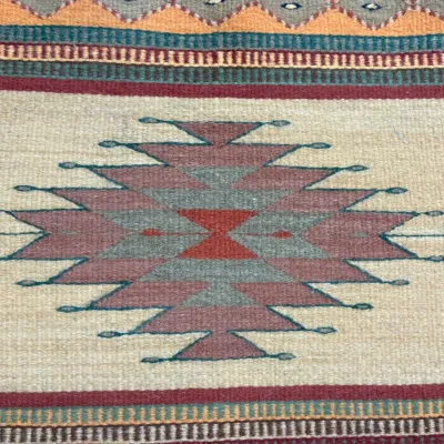 Sale Photo Thumbnail #421: Handwoven Southwestern or Native American style wool rug featuring geometric diamond patterns and striped borders in muted earth tones.