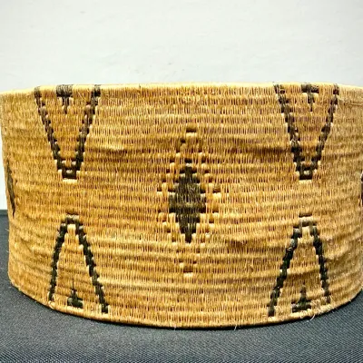 Sale Photo Thumbnail #27: Handwoven Native American style basket hat featuring dark geometric chevron and diamond motifs over a natural fiber weave.