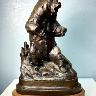 Sale Photo Thumbnail #117: Bronze sculpture of a roaring grizzly bear titled 'Grizzly Bear' by James L. Clark, mounted on a molded wooden base with an engraved brass plaque.