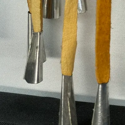 Sale Photo Thumbnail #404: Close-up of Native American-style tin jingles attached to tan leather fringe straps.