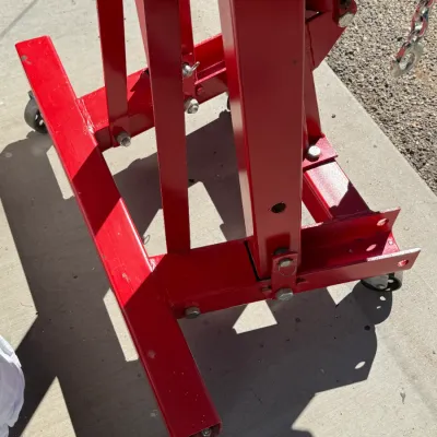 Sale Photo Thumbnail #511: Red folding engine hoist base with casters and hydraulic ram mechanism, showing light surface wear.