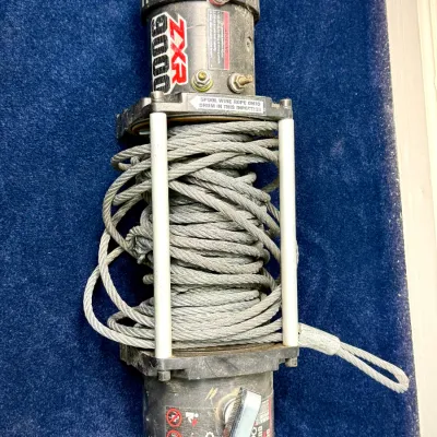 Sale Photo Thumbnail #662: Badland ZXR 9000-lb capacity vehicle electric winch with attached steel wire rope, showing light wear from use.