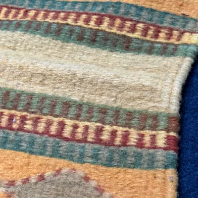 Sale Photo Thumbnail #428: Close-up detail of a hand-woven wool Kilim rug featuring striped geometric patterns in earth tones, maroon, and green.