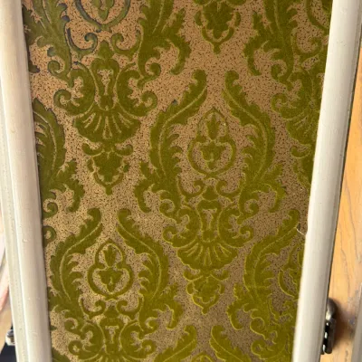 Sale Photo Thumbnail #271: Close-up of a vintage cabinet door panel featuring a 1970s green flocked flock damask pattern with a gold foil background.