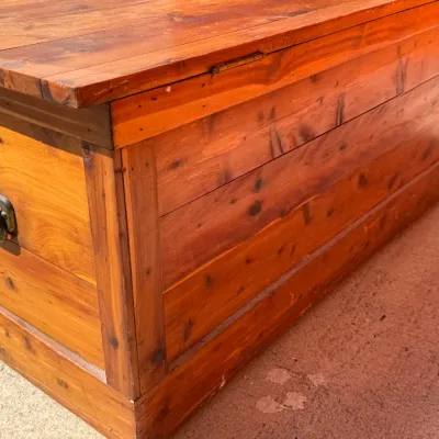 Sale Photo Thumbnail #321: Rustic solid wood cedar trunk featuring metal side drop handles and a natural warm stain finish.