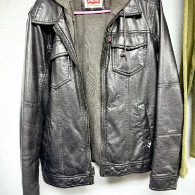 Sale Photo Thumbnail #877: Levi's men's faux leather hooded jacket with a knit fabric inner lining and drawstring hood, showing light wear and small paint spots on the lower front.
