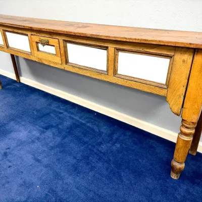 Sale Photo Thumbnail #274: Rustic antique oak console table or store counter featuring white accent panels, turned front legs, and a single central drawer with a metal pull.