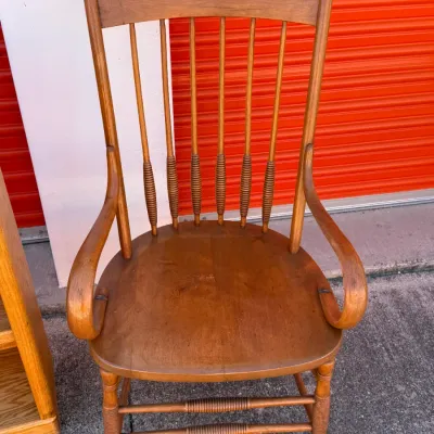 Sale Photo Thumbnail #704: Vintage wooden arm chair featuring spindle back supports, turned stretchers, and finial accents.