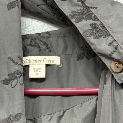 Sale Photo Thumbnail #899: Coldwater Creek grey embroidered jacket in size 12, featuring delicate floral embroidery detail and decorative shell buttons.