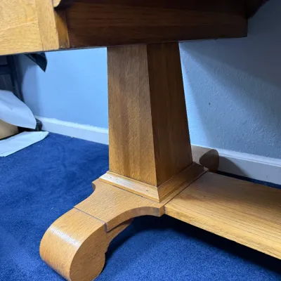 Sale Photo Thumbnail #683: Detail of an antique oak trestle dining table showing a sturdy pedestal leg base and scroll foot.