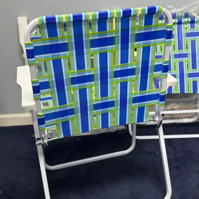 Sale Photo Thumbnail #917: Vintage-style folding lawn chair featuring blue and green woven webbing on a white metal frame.