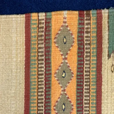 Sale Photo Thumbnail #420: Detail of a Southwestern or Mexican style hand-woven textile featuring geometric diamond and stripe patterns in earth tones.