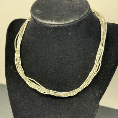 Sale Photo Thumbnail #178: Multi-strand liquid silver necklace displayed on a black velvet jewelry mannequin.