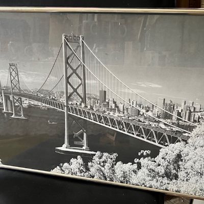 Framed black-and-white panoramic photograph depicting the San Francisco-Oakland Bay Bridge and city skyline.