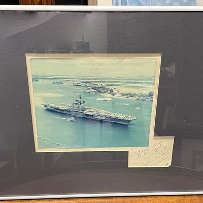 Framed vintage color aerial photograph of a U.S. Navy aircraft carrier at sea, with a handwritten inscription.