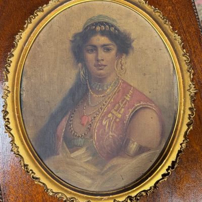 Antique oval portrait print of a woman in Orientalist-style attire, set within an ornate gilded frame with acanthus leaf finials.