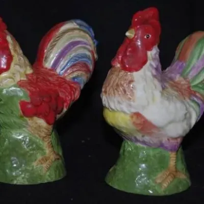 Pair of vintage hand-painted ceramic rooster salt and pepper shakers featuring colorful feather details and green bases.