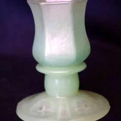 Vintage pale green iridescent glass candle holder featuring a tulip-shaped top and a wide patterned pedestal base.