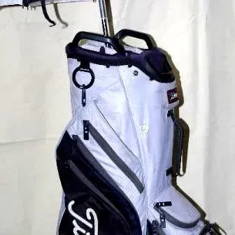 Titleist light grey and black cart golf bag featuring an attached black and white umbrella.