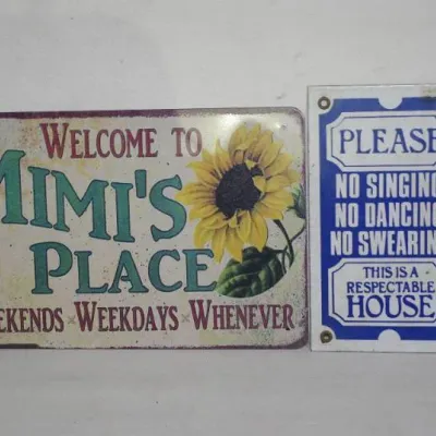 Two vintage-style tin signs featuring a sunflower 'Mimi's Place' welcome sign and a blue and white 'Respectable...