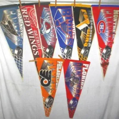 Collection of vintage NHL team felt pennants, including Detroit Red Wings, Montreal Canadiens, and Philadelphia Flyers, displayed on...